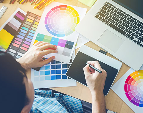 Graphic designer drawing on graphics tablet at workplace