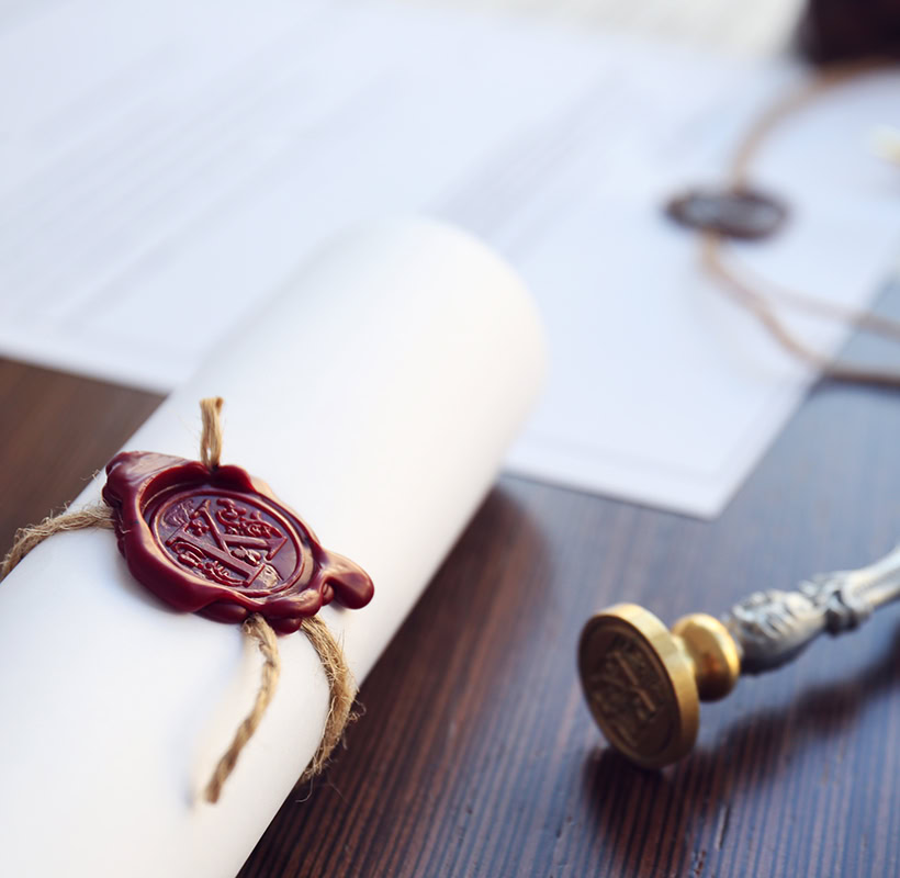 Tied scroll with old notarial wax seal and stamp on table