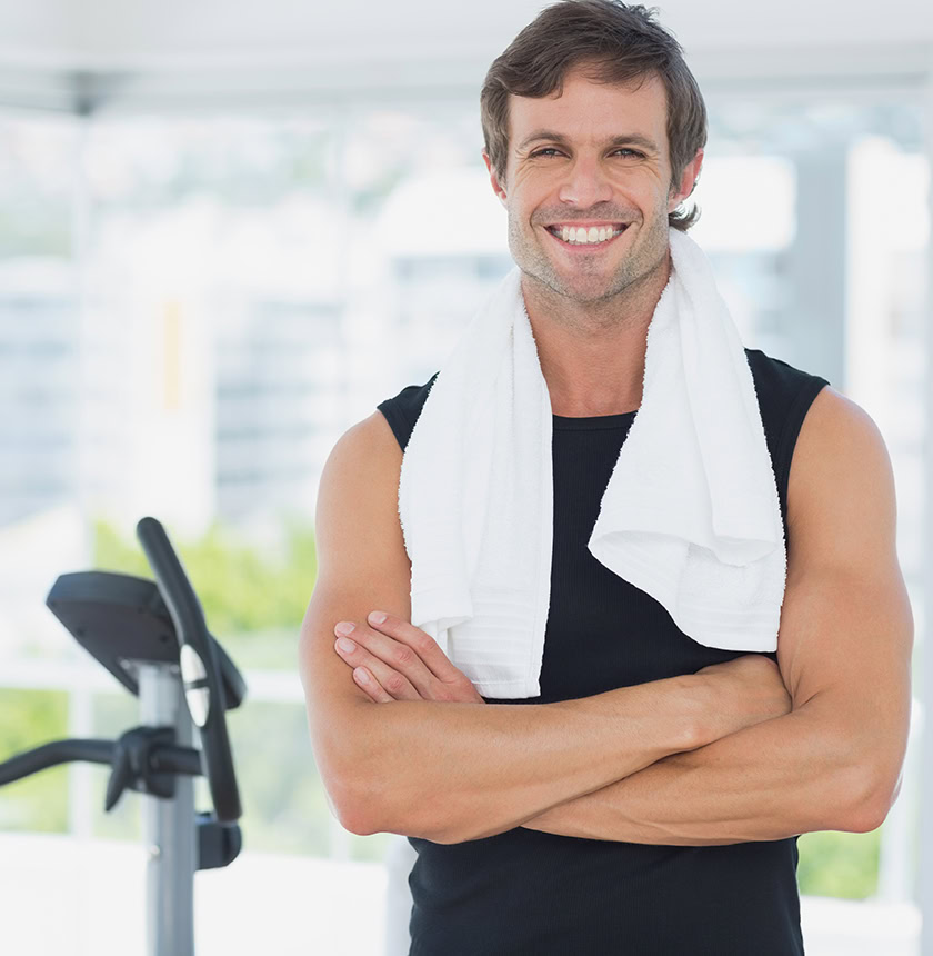 Smiling man with arms crossed finishing elliptical workout