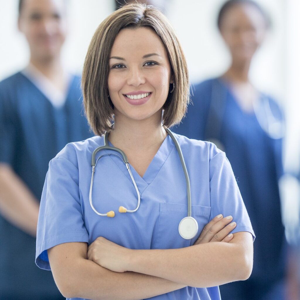 Female nursing student in scrubs with stethoscope, smiling confidently.