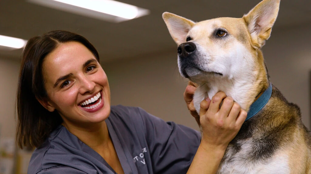 Happy woman with a dog in an indoor setting at Platt College.